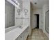 Bright bathroom featuring a long vanity with white countertops, a large mirror, and neutral tile flooring at 4512 Evan Ct, Hoschton, GA 30548