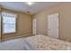 Cozy bedroom with a soft, floral patterned bedspread and bright natural light from a large window at 4512 Evan Ct, Hoschton, GA 30548