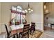 Bright dining room features an elegant chandelier, large window, and beautiful floral rug at 4512 Evan Ct, Hoschton, GA 30548