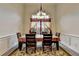 Elegant dining room with a window, decorative rug, and classic wainscoting detail at 4512 Evan Ct, Hoschton, GA 30548