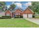 Charming red brick home featuring a well-manicured lawn and two-car garage at 4512 Evan Ct, Hoschton, GA 30548