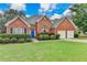 Attractive brick home with manicured landscaping, double garage and bright blue door at 4512 Evan Ct, Hoschton, GA 30548