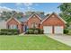 Beautiful brick home with a well-kept lawn, blue front door, and two-car garage at 4512 Evan Ct, Hoschton, GA 30548