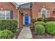 Inviting entryway with a bright blue door and lush, manicured landscaping at 4512 Evan Ct, Hoschton, GA 30548