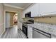 Bright kitchen with stainless steel appliances, granite countertops, and wood-look floors at 4512 Evan Ct, Hoschton, GA 30548