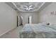 Spacious main bedroom with tray ceiling, carpet, and views to the ensuite bath at 4512 Evan Ct, Hoschton, GA 30548