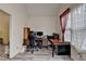 Well-lit office featuring a dark wood desk, rolling chair, and shelving unit at 4512 Evan Ct, Hoschton, GA 30548