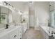 Bright bathroom featuring double vanities, modern fixtures, and a glass shower door at 5030 Princeton Trce, Cumming, GA 30041