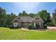 Charming single-story brick home with lush green lawn and manicured landscaping on a sunny day at 5030 Princeton Trce, Cumming, GA 30041