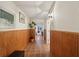 Hallway with wood paneling, tile floors, and a view into the living room at 5030 Princeton Trce, Cumming, GA 30041