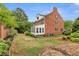 Expansive backyard with mature trees, brick wall, manicured lawn, and patio, providing a private outdoor space at 100 Barnard Pl, Atlanta, GA 30328