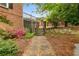 Beautifully landscaped backyard with stone pathway, flowering bushes, and mature trees offering a serene outdoor setting at 100 Barnard Pl, Atlanta, GA 30328