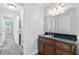 Bathroom with a vanity, mirror, and decorative lighting fixtures and hall access to bedroom at 100 Barnard Pl, Atlanta, GA 30328