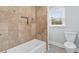 Clean bathroom features a tiled shower, a modern toilet, and a window for natural light at 100 Barnard Pl, Atlanta, GA 30328