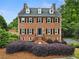 Elegant brick two-story home featuring symmetrical windows, black shutters, and manicured landscaping at 100 Barnard Pl, Atlanta, GA 30328