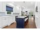 Spacious kitchen with white cabinets, a blue island, breakfast bar, and backyard views at 100 Barnard Pl, Atlanta, GA 30328