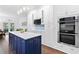 Modern kitchen with a navy blue island, white countertops, stainless steel appliances, and ample storage at 100 Barnard Pl, Atlanta, GA 30328