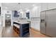 Bright kitchen with white cabinets, a stainless steel refrigerator, and an island with a breakfast bar at 100 Barnard Pl, Atlanta, GA 30328