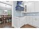 Bright kitchen with stainless appliances, white cabinets, blue backsplash, and adjacent dining area at 100 Barnard Pl, Atlanta, GA 30328