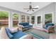 Inviting sunroom featuring wicker seating, bright colorful rug, and natural light at 100 Barnard Pl, Atlanta, GA 30328