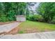 A spacious backyard with a storage shed, driveway, and green grass at 1774 Austin Dr, Decatur, GA 30032