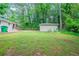 This backyard features lush grass, surrounding woods and home and shed exteriors at 1774 Austin Dr, Decatur, GA 30032