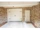 Attached garage with a door, exterior brick, and a cozy 'Home' welcome mat on the concrete at 2448 Gatebury Cir, Atlanta, GA 30341