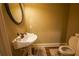 Small powder room features a pedestal sink, an oval mirror, and a toilet at 2448 Gatebury Cir, Atlanta, GA 30341