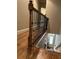A staircase with hardwood floors and black metal railings lead downstairs at 2448 Gatebury Cir, Atlanta, GA 30341
