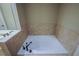 Tiled-in soaking tub with tile surround and bronze faucet, creating a serene spa-like experience at 2448 Gatebury Cir, Atlanta, GA 30341