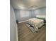 Cozy bedroom featuring wood floors, two windows, and a comfortable bed with a patterned comforter at 4909 Glenwhite Dr, Duluth, GA 30096