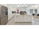 Well-lit kitchen featuring an island, white cabinetry, stainless appliances, and patterned tile flooring at 4909 Glenwhite Dr, Duluth, GA 30096