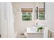 Bright bathroom with white tile, modern fixtures and a window view at 2685 Flagstone Se Dr, Atlanta, GA 30316