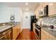 Galley kitchen with stainless steel appliances, granite countertops, and tile backsplash at 335 W Ponce De Leon Ave # 308, Decatur, GA 30030