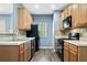 Efficient kitchen featuring oak cabinets, black appliances, and wood-look flooring at 3366 Thornbridge Dr, Powder Springs, GA 30127