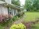 Charming pathway lined with colorful roses and lush greenery enhance curb appeal at 770 Starrsville Rd, Covington, GA 30014