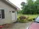 Exterior door and a colorful rose bush, adding charm to the side of the property at 770 Starrsville Rd, Covington, GA 30014