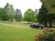 Landscaped front yard with lush green lawn, flowerbeds, and a paved driveway leading to a parked SUV at 770 Starrsville Rd, Covington, GA 30014