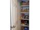 Pantry with multiple shelves stocked with a variety of food items behind a white paneled door at 770 Starrsville Rd, Covington, GA 30014