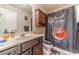 Bathroom featuring a shower over tub, a sink with vanity, and sporty basketball decor at 882 Nestling Dr, Lawrenceville, GA 30045