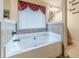 Bathroom boasting a soaking tub under a window, tiled surround, and modern fixtures at 882 Nestling Dr, Lawrenceville, GA 30045