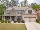 Charming two-story brick home with a manicured lawn, a two-car garage, and mature trees at 882 Nestling Dr, Lawrenceville, GA 30045