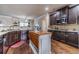 Spacious kitchen featuring dark wood cabinets, an island with butcher block, and granite countertops at 882 Nestling Dr, Lawrenceville, GA 30045