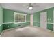 Green-painted bedroom featuring a ceiling fan, a large window, and wall trim detail at 1055 Heather Ct, Lawrenceville, GA 30043