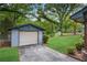 Detached one-car garage with lush greenery on a well-maintained lawn and a cracked driveway at 1055 Heather Ct, Lawrenceville, GA 30043
