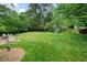 Spacious backyard with lush green lawn, mature trees, and a playset offering a serene outdoor retreat at 1470 Rhododendron Nw Dr, Acworth, GA 30102