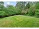 Expansive backyard showcasing a well-maintained lawn and mature trees creating a private oasis at 1470 Rhododendron Nw Dr, Acworth, GA 30102