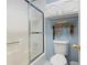 Bathroom featuring a tub with sliding glass doors, a toilet and storage cabinets with decor at 1470 Rhododendron Nw Dr, Acworth, GA 30102
