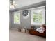 Light-filled bedroom featuring two windows, neutral walls, and a charming round mirror with wreath at 1470 Rhododendron Nw Dr, Acworth, GA 30102