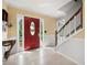 Bright foyer features a red door, tile flooring, neutral walls, and a staircase with white railings at 1470 Rhododendron Nw Dr, Acworth, GA 30102